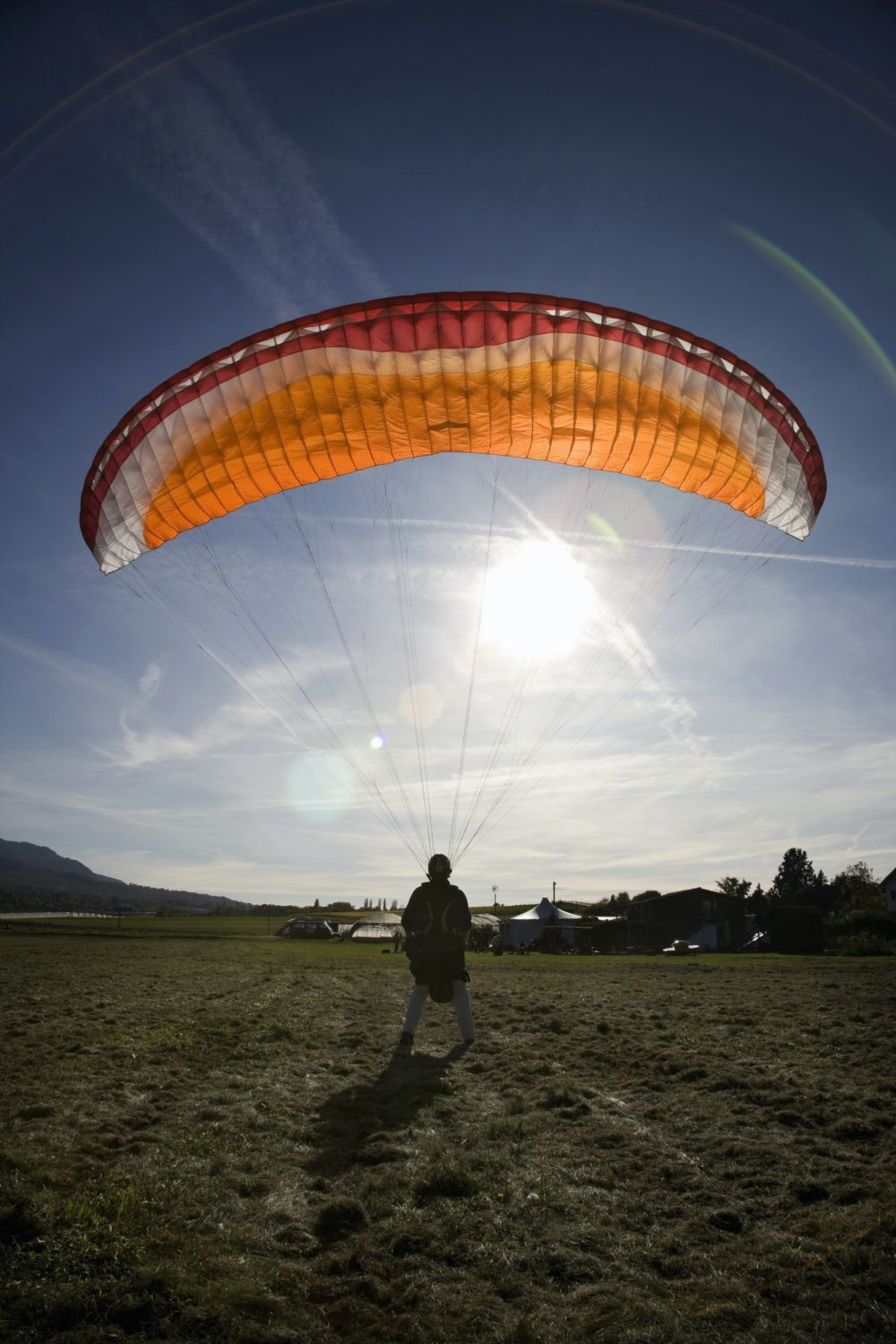 mature-male-paraglider-landing-with-parachute-mount-saleve-geneva-switzerland-e1655954863772